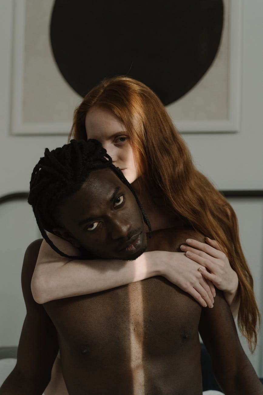 a woman hugging a shirtless man